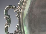 an antique silver plate with a handle and handles on a table