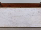 a white marble box with a brown handle on the floor