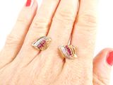 someones hand holding a pair of rings with a red and white diamond