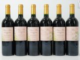 six bouteilles de vin sont alignées sur une surface blanche