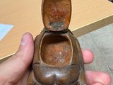 a person holding a small wooden object in their hand
