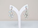 a close up of a pair of earrings on a white stand