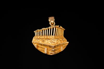 une image représentant un pendentif plaqué or sur lequel figure un bâtiment