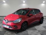 une voiture rouge est garée dans une pièce au sol en damier