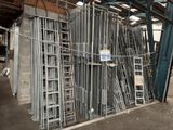 a large pile of metal ladders in a warehouse