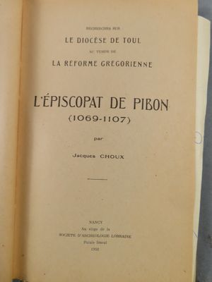 un livre ouvert posé sur une table à côté d'une tasse de café