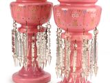 two pink vases with beads hanging from them