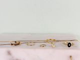 trois paires de boucles d'oreilles dorées et noires posées sur une plaque de marbre blanc