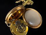 a gold pocket watch with a stone inside of it