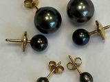 three pairs of black pearl earrings and a pair of gold earrings