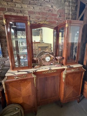 une armoire en bois sur laquelle sont posés un miroir et une horloge