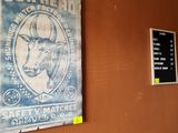 posters on the wall of a restaurant with a cow head on it