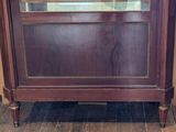 a wooden cabinet with a glass door on top of it