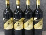 quatre bouteilles de vin sont alignées sur une table