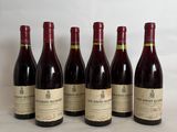 six bottles of wine are lined up on a table