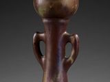 a brown vase with two handles on a black background