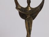 bronze statue of a woman holding a crescent on a white surface