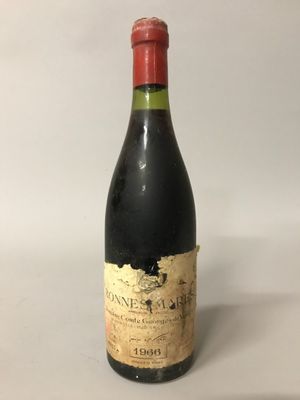 une vieille bouteille de vin posée sur une table blanche