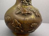 un vase en bronze orné d'un oiseau et de fleurs