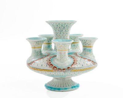 a vase that has five cups on top of it