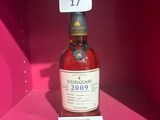 La bouteille de whisky est exposée dans la boîte rose.