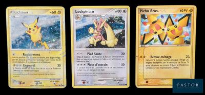 trois cartes Pokémon présentant des motifs différents sur un fond noir