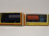 deux jouets emballés représentant un camion bleu et orange et un camion bleu et orange