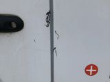 a close up of a white van with a red cross sticker on it