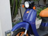 a scooter that is parked next to a wall