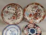 three plates with asian designs on them sitting on a white surface