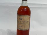 an old bottle of wine sitting on top of a white table