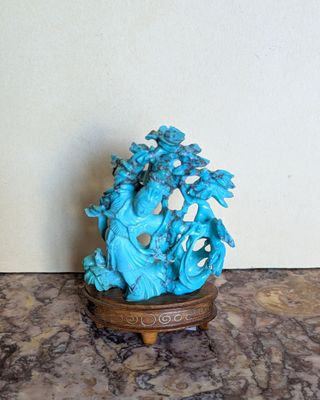 une statue bleue représentant un homme et une femme, posée sur une table