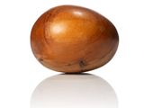 a wooden egg that is sitting on a white surface