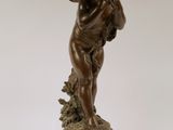 an antique bronze statue of a boy holding a book