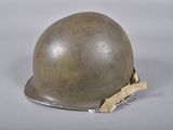an old helmet is sitting on a table with a piece of tape around it