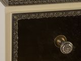 a black and gold dresser with a mirror on top of it