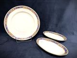 two plates and a bowl on a stand on a black background