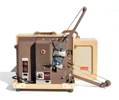 un vieux projecteur de cinéma posé sur un socle en bois