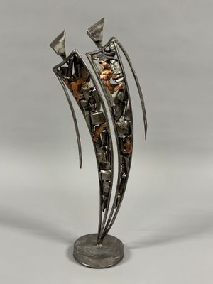 des sculptures en métal sont exposées sur un socle posé sur une surface blanche