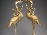 pair of brass candlesticks with birds on top of them