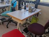 a desk with a chair and a sewing machine in the room