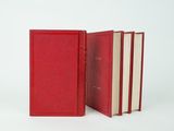 two red books sitting next to each other on a white surface