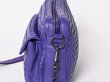 a close up of a purple purse on a white surface