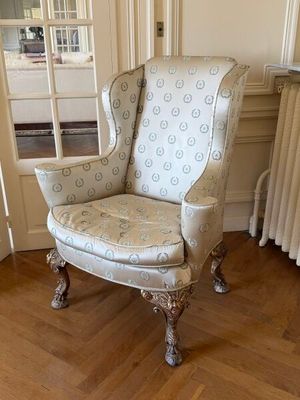 a chair in the corner of a room with a radiator