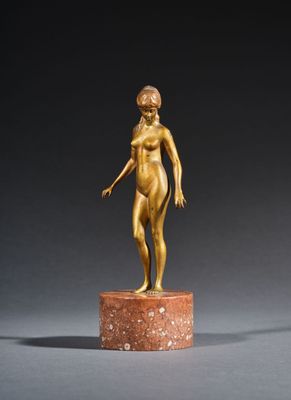 a gold statue of a woman standing on top of a marble base