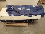 a mattress and a blanket on a pallet in a warehouse