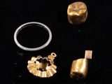 two gold rings and a silver ring on a black surface
