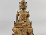 une statue en or représentant un Bouddha assis sur une table
