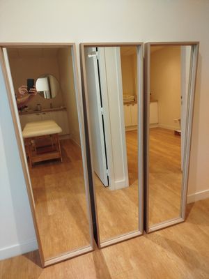 une personne en train de prendre une photo d'un miroir dans une pièce