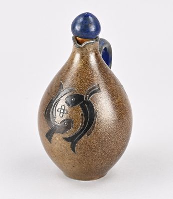 un vase marron orné d'un motif noir